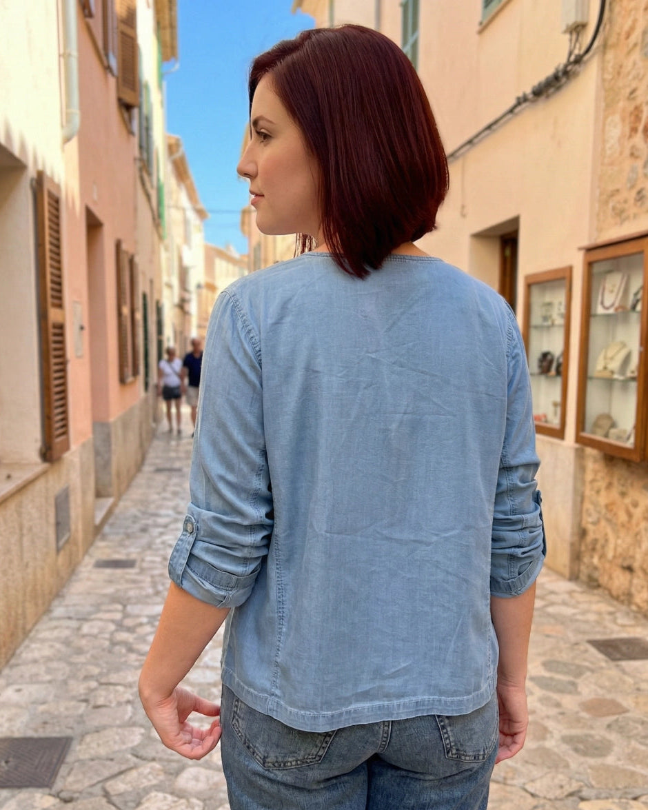 Woman walking down a narrow street in a Mediterranean-style town.